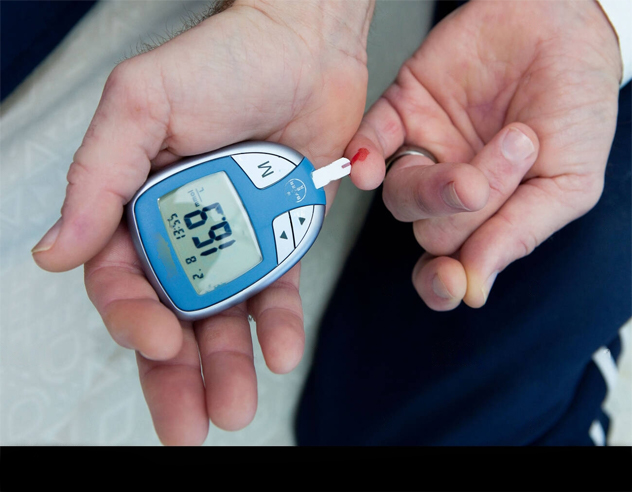hands holding a glucometer